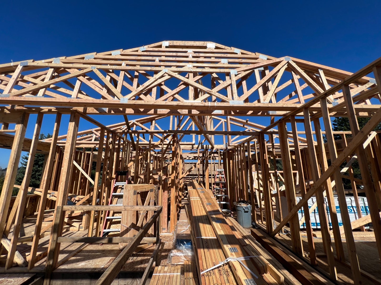 Framing of a room addition with roof trusses under a clear sky