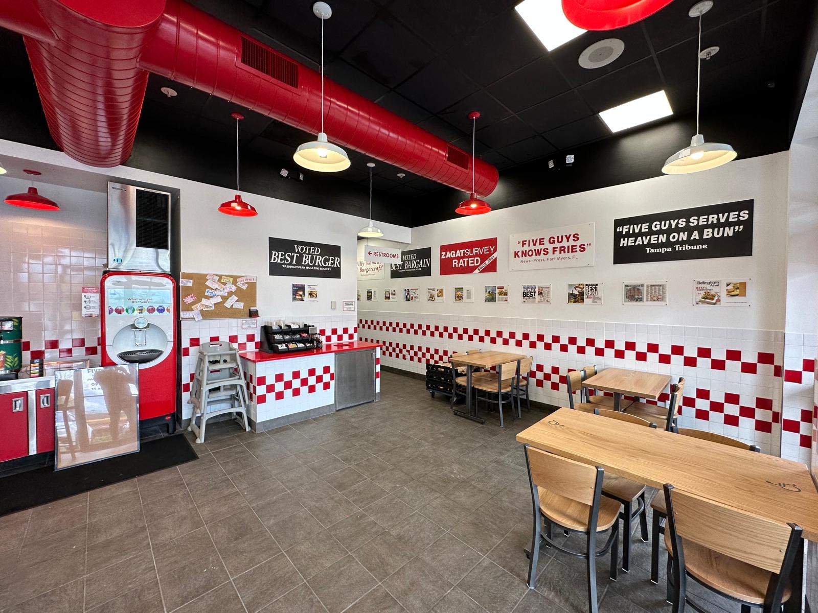 Five Guys dining room with press-clipping wall display and seating