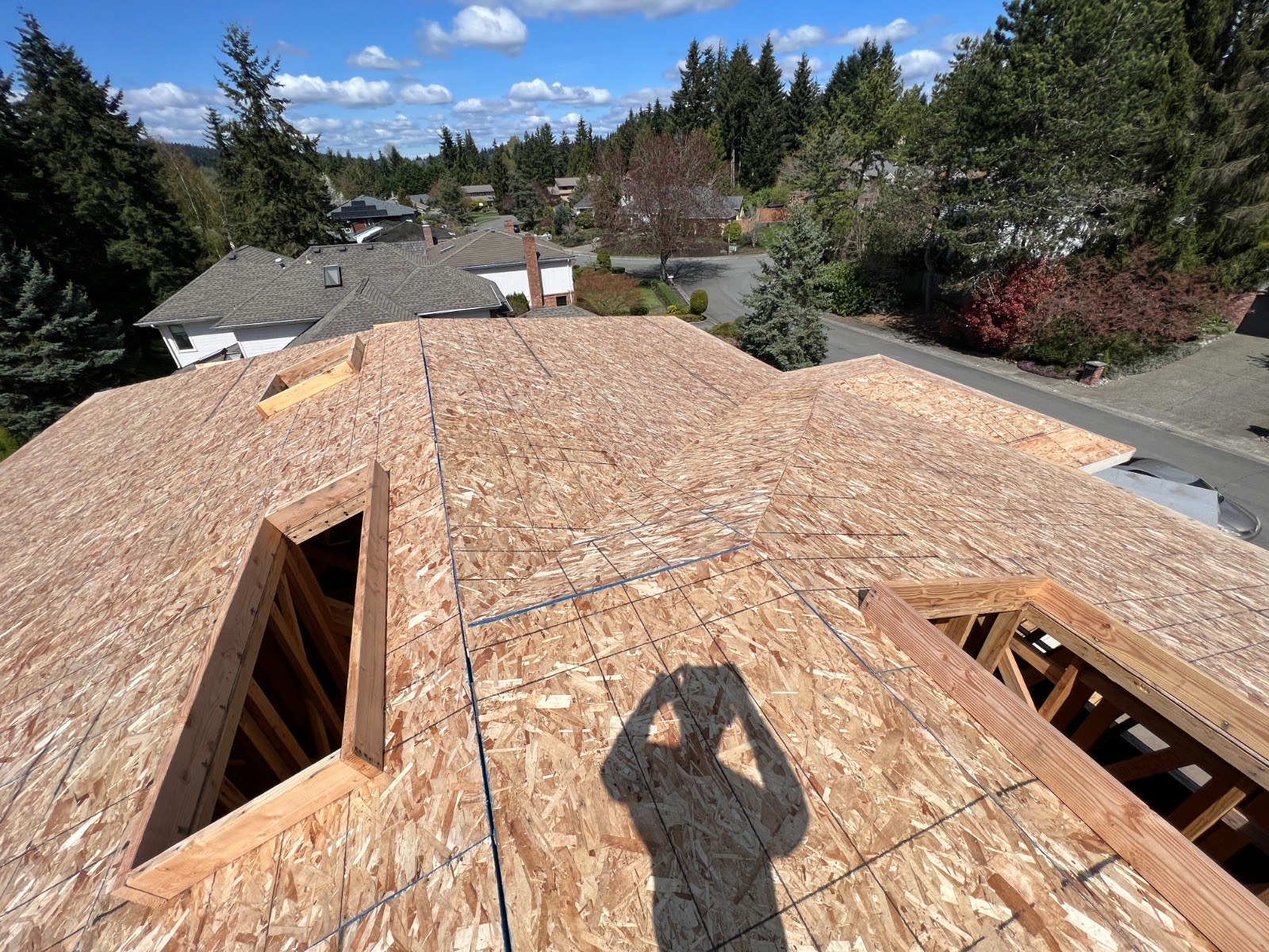 Aerial view of roof sheathing installation on a two-story custom home